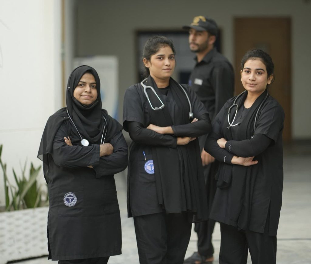 Nursing students in uniform standing outside New International College of Nursing & Health Sciences in Pakistan.